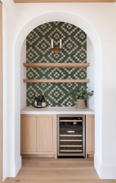 a wine cellar in the corner of a room with wooden shelves and green patterned wallpaper