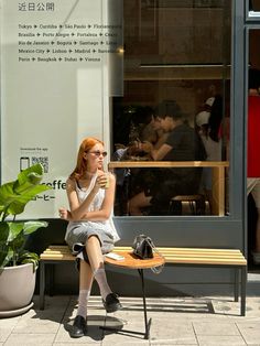a woman sitting on a bench in front of a store