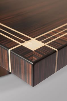 a close up of a wooden table with gold lines on the top and bottom edge