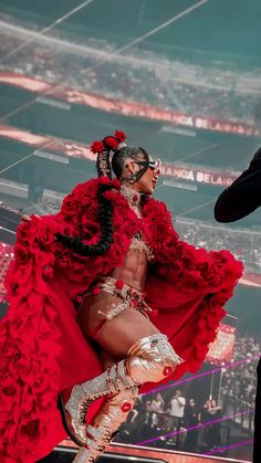 a woman in a red dress is dancing on stage