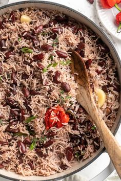 a pot filled with rice and beans on top of a white countertop next to sliced tomatoes