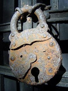 an old rusted padlock on the side of a building
