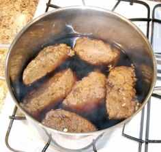some meat is cooking in a pot on the stove