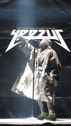 a man standing in front of a microphone on top of a stage with an umbrella