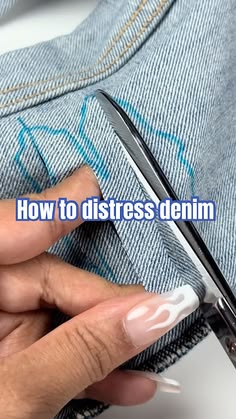 a woman is cutting through her jeans with scissors