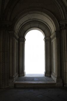 an arch in the middle of a building with stone floors and arches on either side