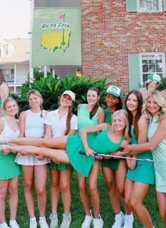 a group of young women standing next to each other in front of a brick building