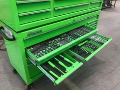 a green tool cabinet with tools in it