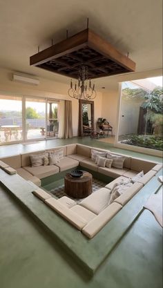 a living room filled with lots of furniture and a chandelier hanging from the ceiling
