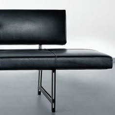 a black leather bench sitting on top of a metal frame