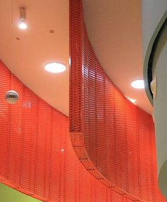 the interior of a building with orange mesh covering it's walls and ceilinging