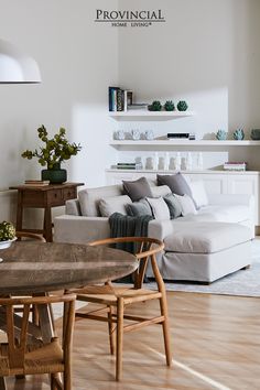 a living room filled with furniture and a wooden table in front of a white couch