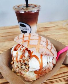 a waffle with ice cream and caramel drizzle on top sits next to a cup of coffee