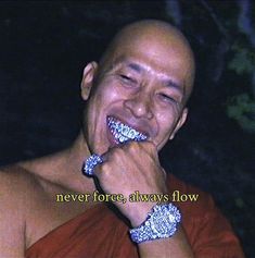 a man is smiling while brushing his teeth with silver bracelets on it's wrist