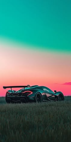 a black sports car parked on top of a lush green grass covered field under a pink and blue sky
