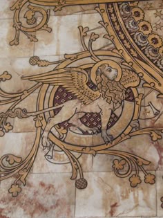 an artistic painting on the side of a building with gold and red designs around it