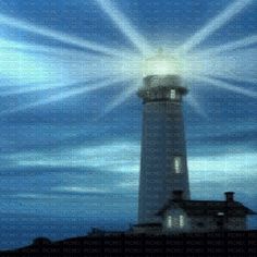 the light house is surrounded by beams of light in the sky above it, as seen from across the water