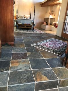 a bedroom with stone flooring and four post bed