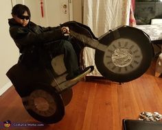 a man sitting on top of a motorcycle made out of tires and other things in front of him