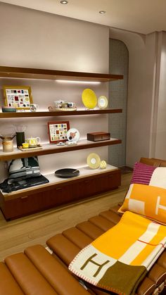 a brown leather chaise lounge chair in front of a shelf filled with plates and bowls