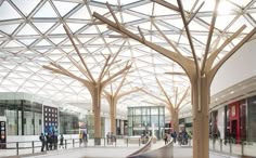 an indoor shopping mall with people walking around