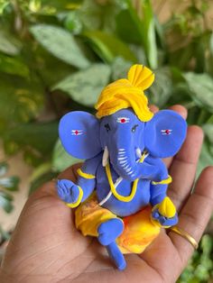 a small blue and yellow figurine in someone's hand