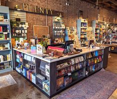 the inside of a book store with many books on shelves and rugs in front of it