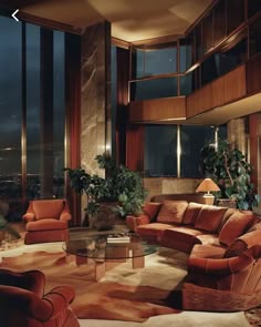 a living room filled with lots of furniture and large windows overlooking the city at night