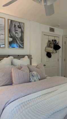 a bedroom with white walls and pictures on the wall