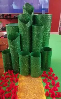 green vases are sitting on a table with red poinsettias around them
