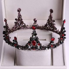 a tiara with red and white stones in a box
