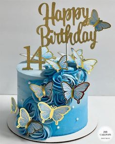 a blue birthday cake with gold butterflies on it and the number four candle in the middle