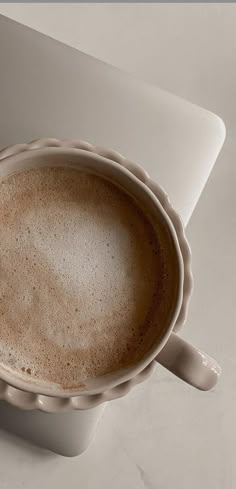 a cup of coffee sitting on top of a white table