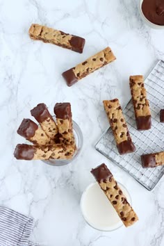 chocolate chip cookie bars on a cooling rack next to a bowl of milk and spoons