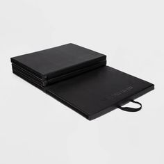 three black notebooks sitting on top of each other
