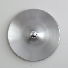 a round metal object on a white surface
