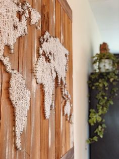 a wooden wall with a world map made out of crochet on the side