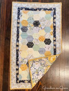 two pieces of quilt sitting on top of a wooden floor