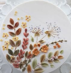 a cake decorated with flowers and leaves on a plate
