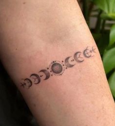 a person with a tattoo on their arm that has phases of the moon and stars