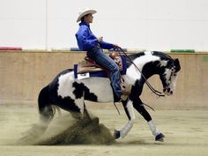 a woman riding on the back of a white and black horse