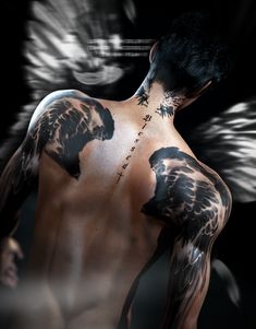 the back of a man's body with tattoos on his chest and wings behind him