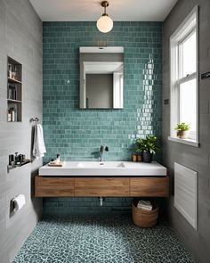 a bathroom with green tile and wooden vanity, mirror above the sink, and plants on the counter