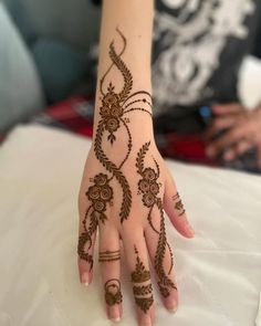 a woman's hand with henna tattoos on it