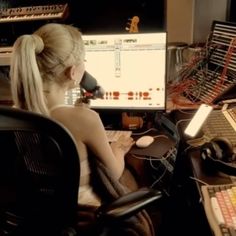 a woman sitting in front of a computer monitor