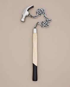 a hammer and chain on a gray background with a black handle that is attached to it