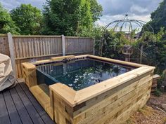 an outdoor hot tub in the middle of a wooden deck
