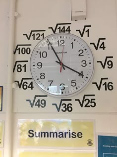 a large clock mounted to the side of a wall with numbers and symbols on it
