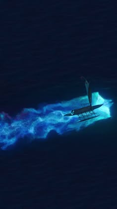 an aerial view of a boat in the ocean with blue and green spray coming out of it