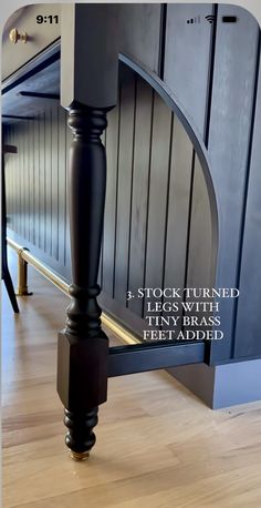an image of a kitchen with wood flooring and black painted cabinets in the background